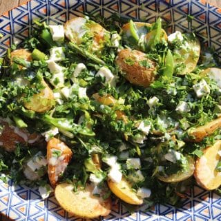 Spring potato salad on large blue, white and orange patterned serving platter