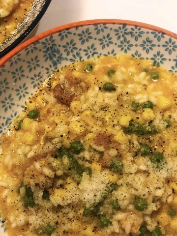 Close up of sausage and pea risotto in patterned pasta bowls