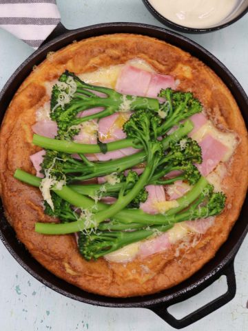 Ham and cheese dutch baby pancake with broccoli in skillet
