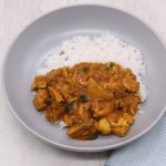 Close up of chicken curry with rice in grey bowl