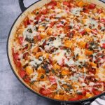 Baked chorizo and squash rice with manchego crust in large round casserole