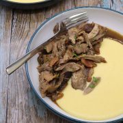 Pheasant ragu with polenta in bowl scattered with parsley