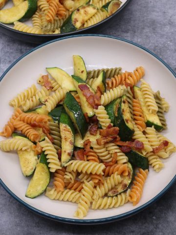 Courgette and bacon pasta in bowls