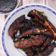 Five spice baked ribs in blue and white bowl with soy dipping sauce