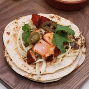 Grilled salmon taco in flour tortilla with coriander and jalapeños