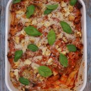 Lamb meatball, red pepper and feta bake in large rectangle oven dish with basil leaves