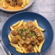 Meatball and mushroom stroganoff on chips in a blue bowl