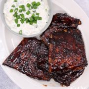 Stickiest ever bbq ribs with chive dip on white oval serving platter