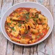 Sausage and pappardelle pasta in grey bowl