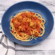 Spicy sausage meatball pasta in blue bowl