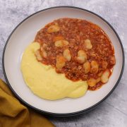 Sausage and white bean ragu with cheesy polenta in a bowl
