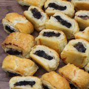 Pork and black pudding sausage rolls on wooden board