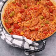 Tomato and chorizo rice in large round casserole with black and white towel