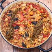 Arroz al horno in large casserole with rosemary sprigs