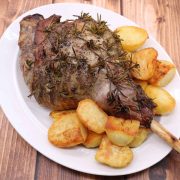 Easy roast leg of lamb with roast potatoes on oval serving platter