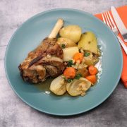 Lamb shank irish stew in green bowl with vegetables