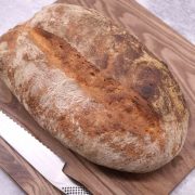 Portuguese Water Bread on wooden board with bread knife