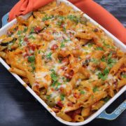 Paprika chicken pasta bake in rectangle oven dish with orange towel