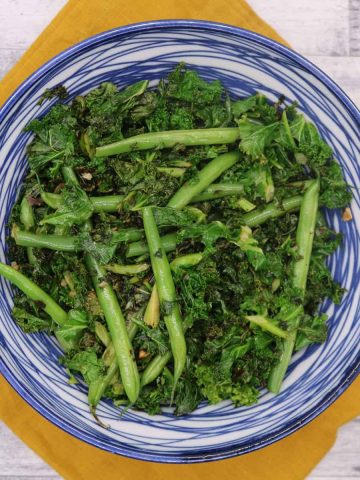 Sauteed kale and green beans in a blue and white bowl