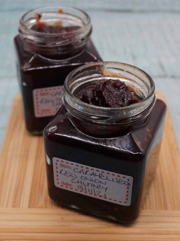 Jar of caramelised red onion chutney on wooden board