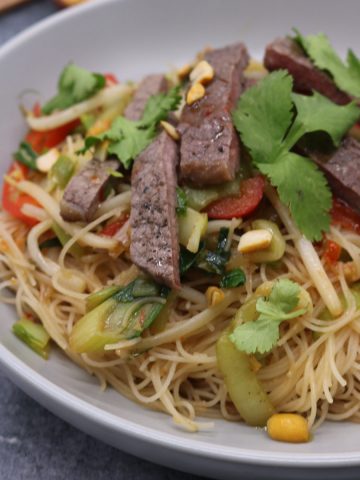 Chilli beef and veg rice noodles in grey bowl