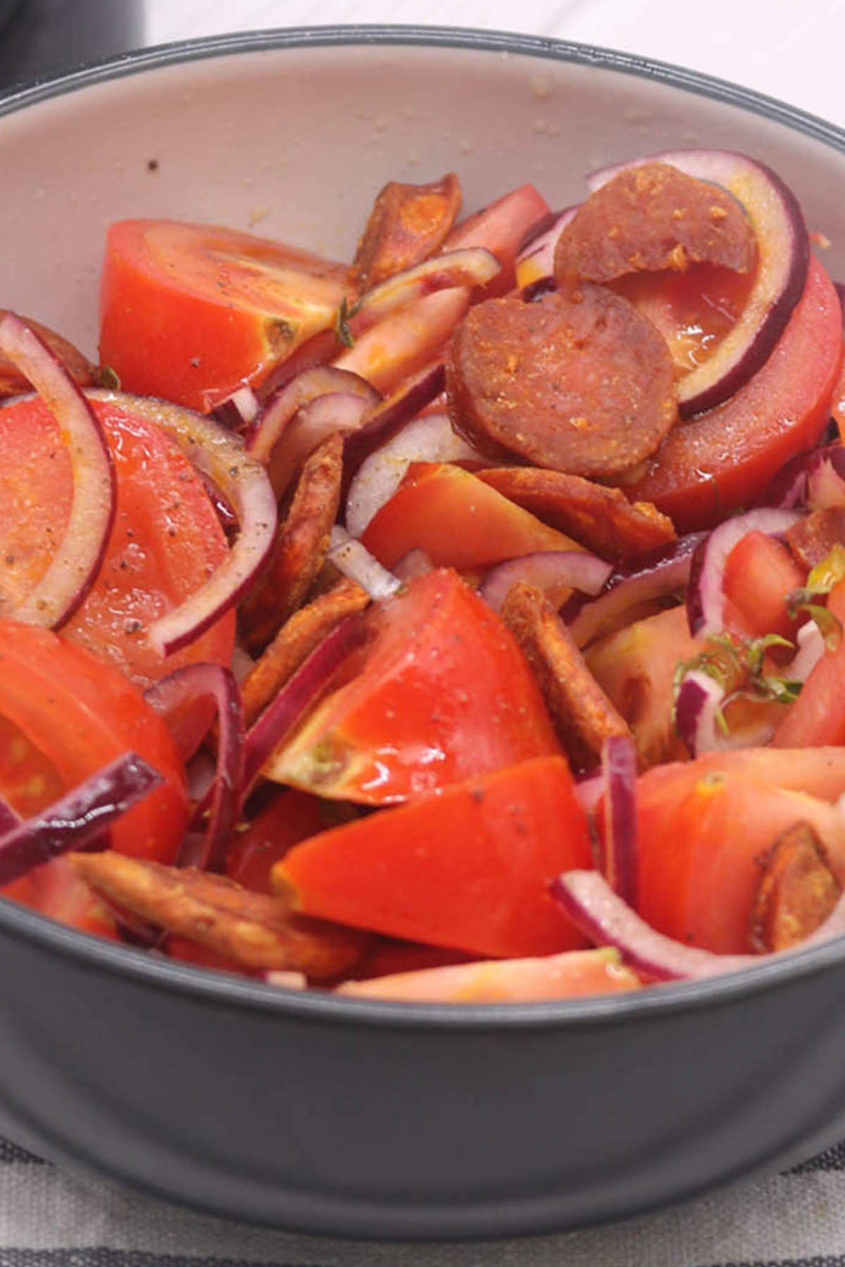 Close up of chorizo and tomato salad in bowl