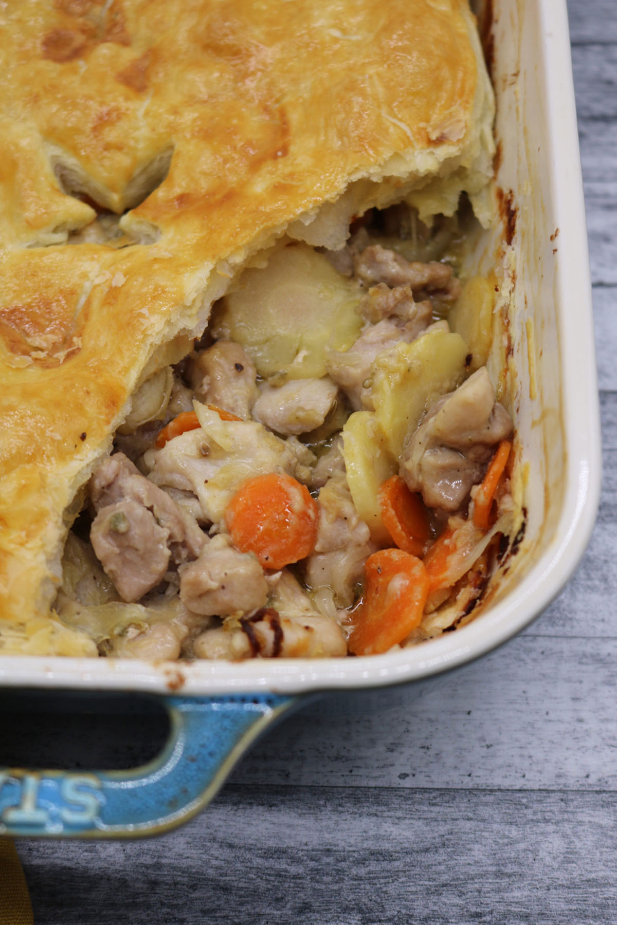 Close up of Easy chicken and vegetable pie in large rectangle oven dish with slice removed