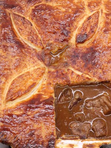Easy steak pie in rectangle oven dish with bottom corner of pastry cut out