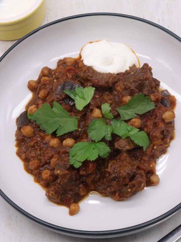 Harissa beef stew in bowl with coriander and soured cream