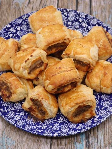 stack of merguez spice sausage rolls on blue and white plate