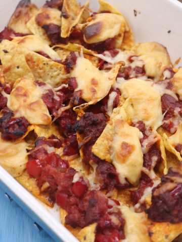 Nachos with chorizo and cheese sauce in rectangle oven dish