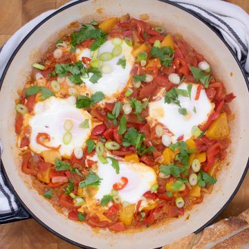 Eggs in a tomato and pepper sauce in a large round casserole