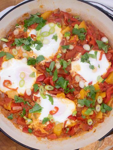 Eggs in a tomato and pepper sauce in a large round casserole