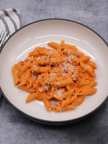 penne alla vodka in bowl with parmesan and chilli flakes