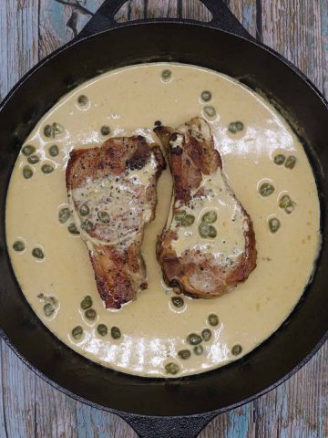 Pork Chops in skillet with mustard and caper sauce