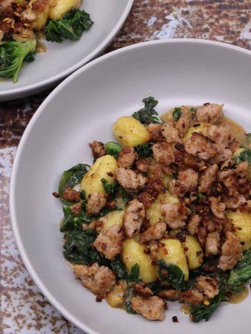 Sausage and kale gnocchi in grey bowls