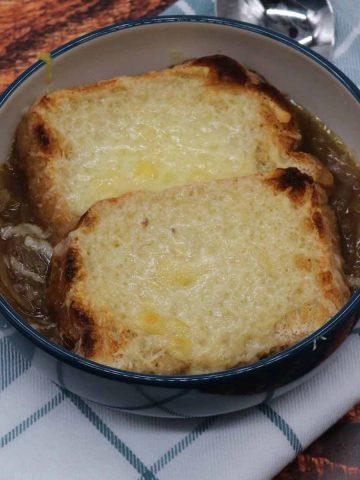 French onion soup in bowl with tow slices of bread covered in cheese