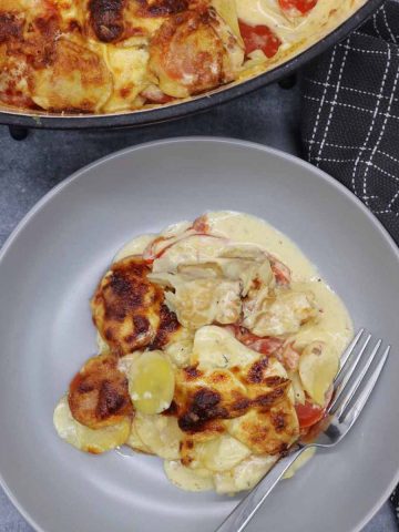 creamy smoked haddock and potatoes in a grey bowl with fork