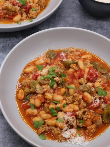 Spicy italian sausage and beans in bowls with parmesan