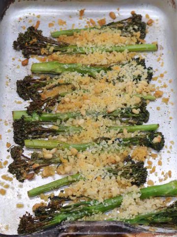 tendereste broccoli in roasting tray covered in pine nuts and breadcrumbs