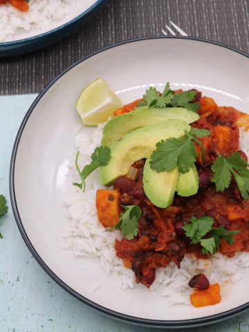 Vegan Chilli in a bowl with rice, avocado, lime and coriander