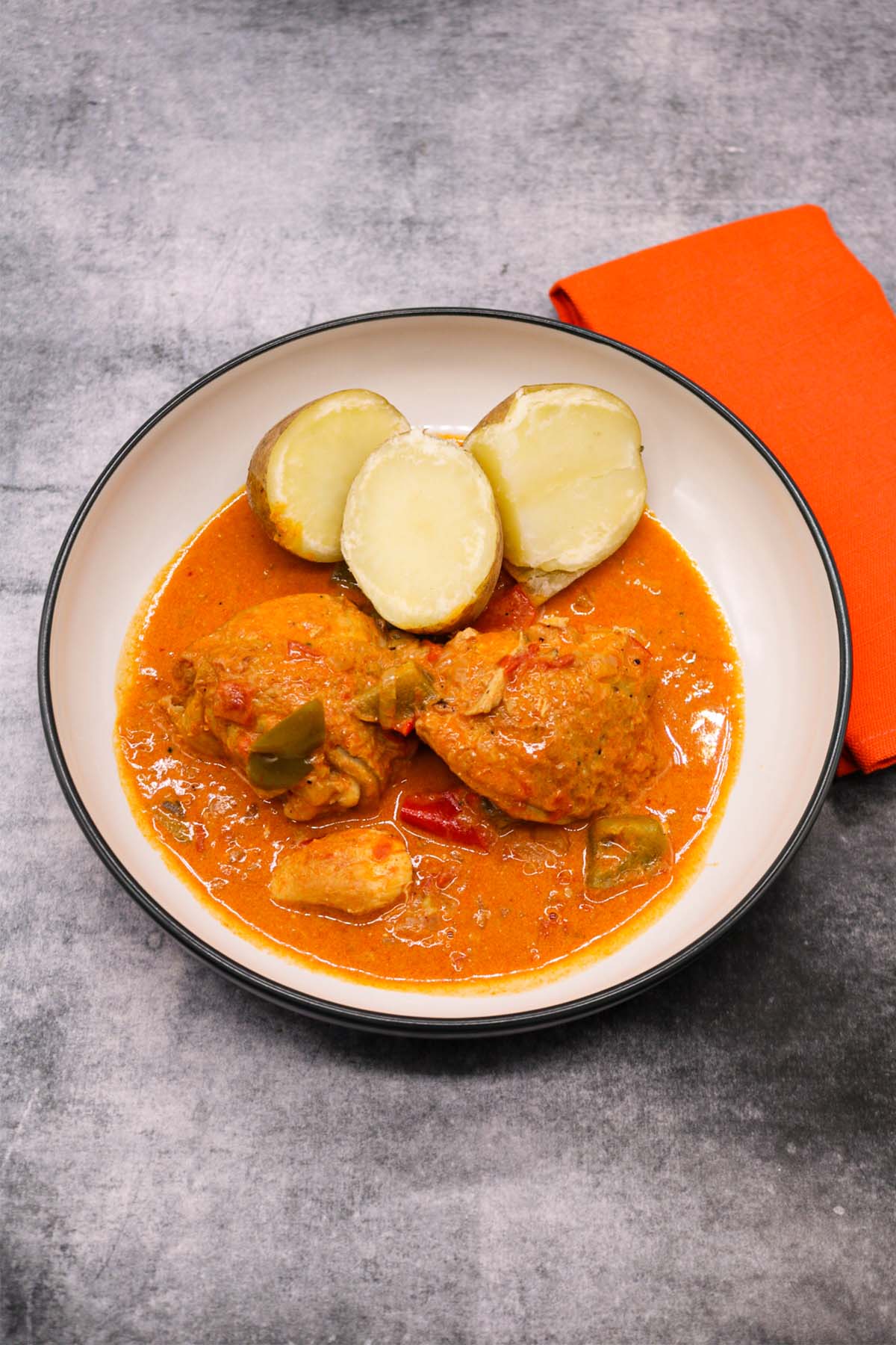 Chicken paprikash in bowl with boiled potatoes