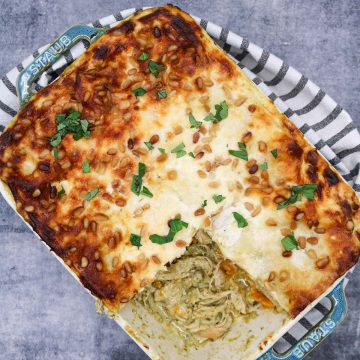 Chicken squash and pesto lasagne in rectangle oven dish with black and white towel