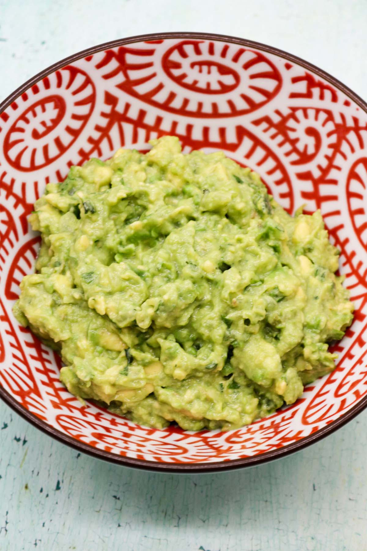 Guacamole in red and white serving bowl