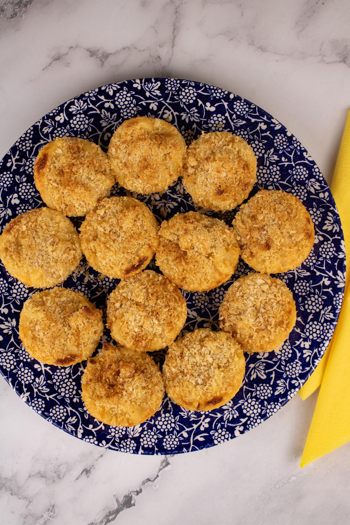 Mac and cheese muffins on blue dinner plate with white berry pattern