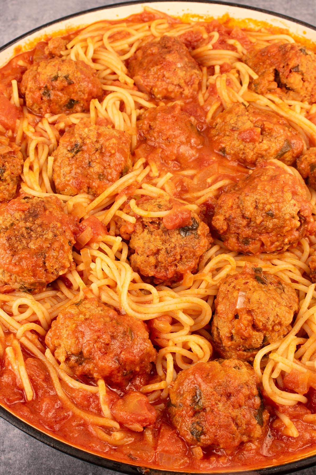 Close up of 'nduja meatballs with spaghetti in large round casserole
