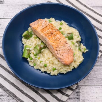 Salmon and spring vegetable risotto in blue bowl