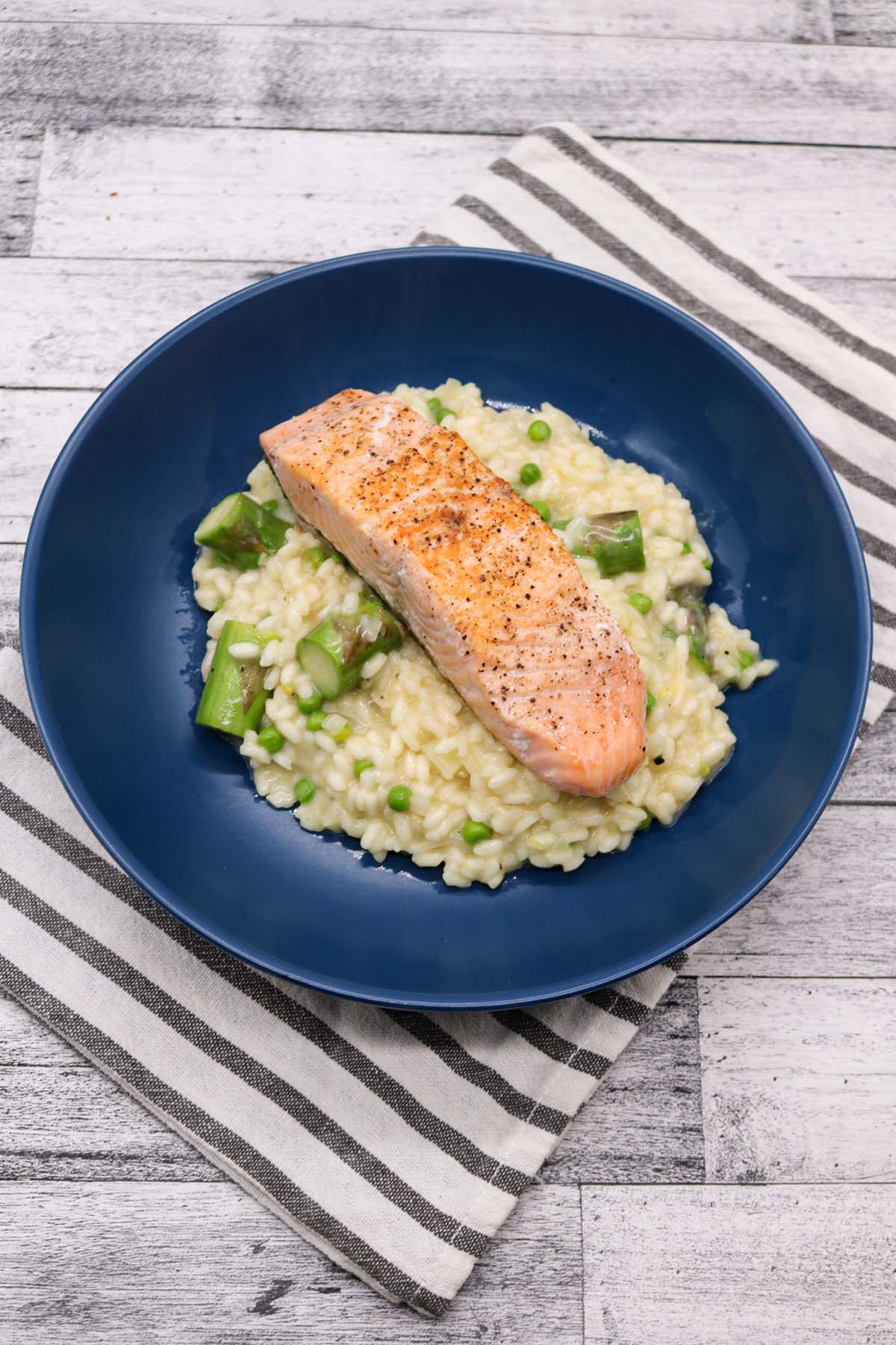 Salmon and spring vegetable risotto in blue bowl