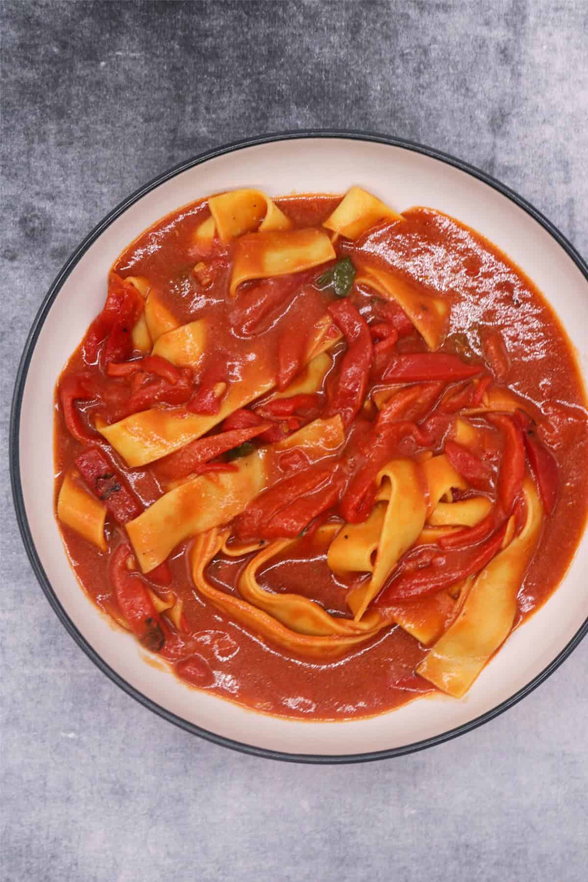 Balsamic pepper pasta in a black and cream pasta bowl.