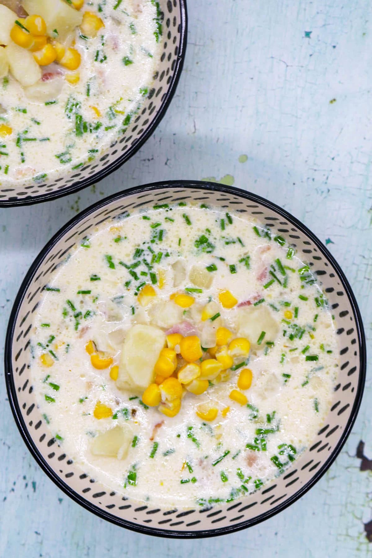 Two bowls of bacon and sweetcorn chowder in black and white patterned bowls.